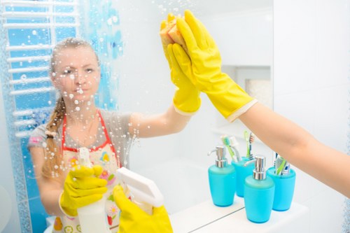 Cleaner wearing PPE while treating a carpet safely